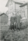 Systrarna Astrid (1907 - 1994, gift Jägerström) och Ingeborg Gustafsson (1901 - 1987, gift Johansson) står utanför hemmet, Kållered Stom 