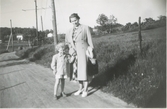 Ingeborg Johansson (1901 - 1987, född Gustafsson) och sonen Lars (född 1945) står på en landsväg, Kållered Stom 