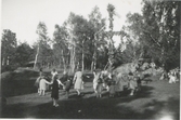 Människor dansar kring midsommarstången, troligtvis på Ekansås 1940-tal. Bilden kommer från ett album från 
