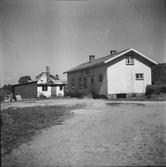 Ernst Larssons hus i Utmossen, Fageråkra, bostadshus och ett par uthus. Mellan Larssons och granngården ligger en mindre byggnad med hög skorsten.