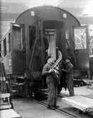Tre män demonterar en passagerarvagn på Centralverkstäderna, 1941