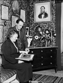 Anders Johnsson tittar i ett fotoalbum, tillsammans med en kvinna, Börstil socken, Uppland