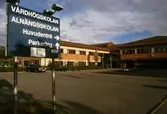 Skylt visar mot entrén till Vårdhögskolan Alnängsskolan, 1989