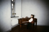 Slottsguide Christel Wedhäll spelar piano på Örebro slott, 1985