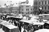 Snön ligger både på Engelbrektsstatyn och på marknadsståndens tak på Hindersmässan, 1985
