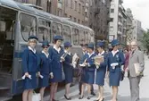 Turistvärdinnorna samlade framför buss, 1967