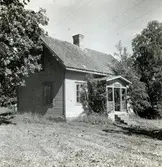 Bostadshus med träfasad, sadeltak, trappa och veranda, Valåkra by.