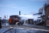 Brandkåren sprutar vatten vid branden vid Gotthards, april 1982