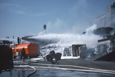 Brandkåren sprutar skum vid branden vid Gotthards, april 1982