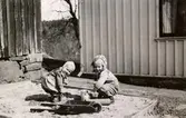 Eva Pettersson (gift Kempe) och kusinen Stina Krantz leker i sandlådan på Torrekulla gård där Eva bor, våren 1947.