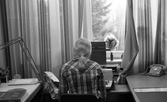 Kontorspersonal läser vid sin skrivmaskin på Byggnadsnämnden, 1974
