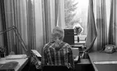 Kontorspersonal läser vid sin skrivmaskin på Byggnadsnämnden, 1974