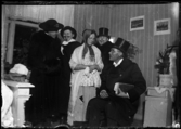 Fyra män och en kvinna utklädda, troligtvis inför maskerad eller teateruppträdande.