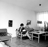 Ungt par sitter i soffa i visningslägenhet på Tengvallsgatan, 1960-tal