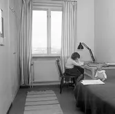 Anna läser vid skrivbordet i sovrummet i Baronbackarna, 1960