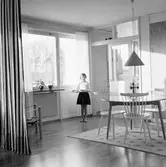 Anna bär bricka med soppa till matbordet i vardagsrummet i Baronbackarna, 1960