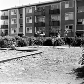 Lekplats med sandlåda och gungande barn i Baronbackarna, 1960-tal