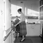 Kerstin Olson förmanar sonen Lars i köket i Baronbackarna, 1960