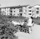 Dagisbarn leker vid bord utanför daghem i Baronbackarna, 1960-tal