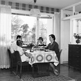 Familjen Enbrant vid matbord i vardagsrum i Baronbackarna, 1960-tal