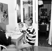 Familjen Enbrants barn äter bullar vid köksbordet, 1960-tal