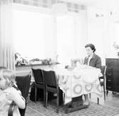 Fru Enbrant vid symaskin i vardagsrummet i Baronbackarna, 1960-tal