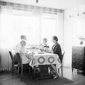 Familj vid matbordet i vardagsrummet i Baronbackarna, 1960-tal