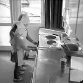 Barn stoppar sin bakplåt i ugnen på daghem i Varberga, oktober 1967