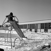 Barn åker rutschkana på lekplats vid daghem i Varberga, oktober 1967