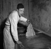 Fiskhandlare Gösta Andersson arbetar med lutfisk inför julen 1953