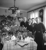 Fyra personer ståendes vid ett stort blomsterbord.