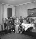 Kvinna sittandes vid blomsterbord.