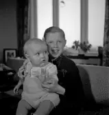 Två barn sittandes i en soffa.