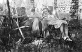 Lennart och Margit vilar i trädgårdsstolar, 1939