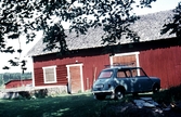 Bilar parkerade framför ladugård i Björkhagen i Hovsta, 1960-tal