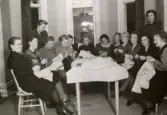 Röda korset har symöte, 1940 - 1945. De höll till i kommunalhuset där det även fanns samlingshus och badhus. Byggnaden låg på platsen där servicehuset nu ligger. Kvinnorna ordnade inför basar för att samla in pengar. Förteckning över namn finns i Kållereds hembygdsförenings arkiv under 228.