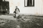 Kjell Johansson (född 1945) och Eva Pettersson (född 1944, gift Kempe) leker i sandlådan vid Torrekulla gård 1947. På bottenvåningen bodde familjen Johansson, familjen Pettersson hyrde på andra våningen.