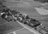 Flygfoto över Kyrkbyn, St. Skedvi. Stora Skedvi kyrka år 1953. Läs mer om Stora Skedvi kyrka i boken: Dalarnas kyrkor i ord och bild.