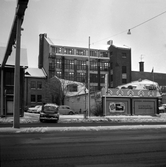 Bil kör ut från parkering vid Skofabriken Vasa och Örebro automobilaffär, 1971 januari