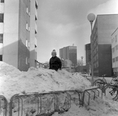 Barn står i snöhög på gården Drottninggatan 56, 1970-tal