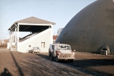 Bilar parkerade vid läktaren och Örnsro ballonghall, 1970-tal