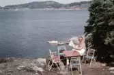 Tidningsläsning vid klippa vid sommarkolonin Anevik, 1960-tal