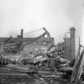 Grävmaskinen tar bort rivningsmassa på Idrottsvägen 14, 1970-tal