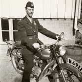 Fritjof (elev boende på Stretereds skolhem) iförd polisuniform, sitter på en motorcykel i Stretered, 1940-tal. Han fick ibland 
