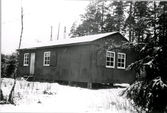 Exteriörbild av Brukshundsklubbens stuga vintertid på Påskbergets friluftsområde. Tillhör samlingen med fotokopior från Hallands Nyheter som är från 1930-1940-talen.