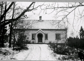 Tre fotografier av folkskolan i Bråtås, Rolfstorp tagna vintertid. Byggnadens två ingångar har 