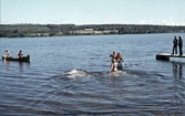 Badande ungdomar och kanoter i badsjö, 1970-tal
