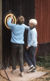 Pojkar kastar pil mot piltavla, 1970-tal
