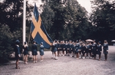 Deltagare i Röda korset hissar svenska flaggan, 1960-tal
