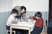 Ungdomsledare ger instruktioner om modellbygge på fritidsgården, 1960-tal